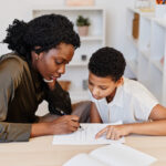 Black Female Tutor Helping Student at Home