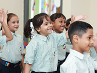 Smiling primary school students raising hands during an interactive classroom session in a Nagpur school