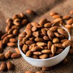 Best flavoured almonds brands in India displayed in bowls with different roasted and seasoned almond varieties.