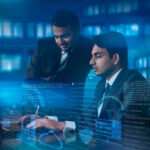 two young Indians working at office on laptop