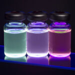hree glowing vials containing fluorescent quantum dot nanocrystal solutions emitting blue, purple, and pink light.