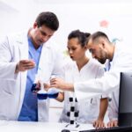 team-scientist-white-coat-working-together-with-smoking-blue-liquid-modern-research-lab (1)