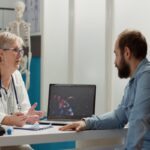 female-medic-looking-coronavirus-illustration-laptop-with-sick-patient-talking-about-medication-prevention-virus-animation-display-cure-disease-medical-cabinet (1)