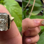 Close-up of a radiant cut diamond statement ring in yellow gold with bold geometric side accents displayed on a fingertip.