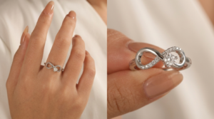 Close-up of two white gold infinity rings on a woman's hand, featuring intertwined and diamond infinity symbol designs.