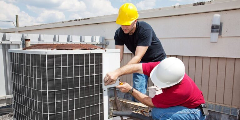 HVAC technicians inspecting and repairing an outdoor air conditioning unit on a rooftop.