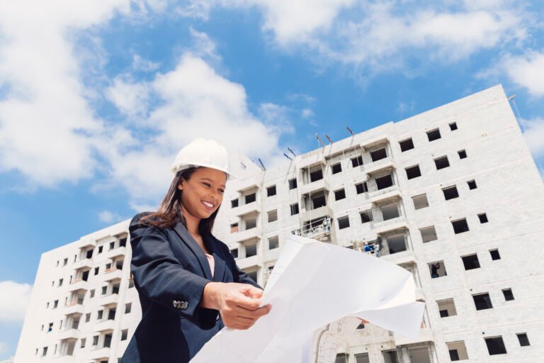 happy-african-american-lady-safety-helmet-with-paper-plan-near-building-construction