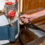 plumbers-hand-connecting-drain-hose-to-water-heater